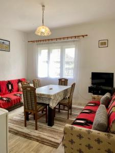 a living room with a table and a couch at Idila pod Rtnjem - Najam cele vikendice sa bazenom in Ilino