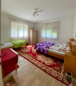 a bedroom with a large bed and a red rug at Idila pod Rtnjem - Najam cele vikendice sa bazenom in Ilino
