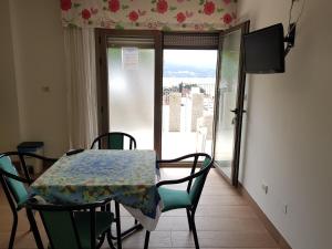 a dining room table and chairs with a view of a balcony at Apartamentos Canada 1 in Raxó