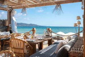 un restaurante en la playa con una hamaca y el océano en La Martina en Sainte-Maxime