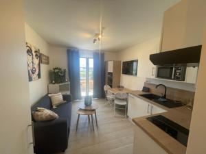 a kitchen and a living room with a table at La Martina in Sainte-Maxime