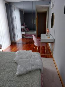 1 dormitorio con cama, escritorio y espejo en Appartement en face de la mer, en Azurara