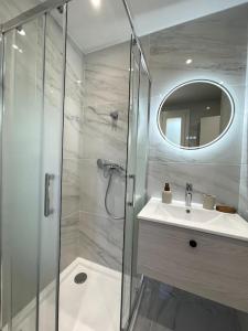 La salle de bains est pourvue d'une douche, d'un lavabo et d'un miroir. dans l'établissement Charmant Studio climatisé avec parking, au cœur de pietranera, plage a 500m, Bastia a 2km, à Palagaccio