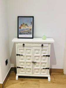 a white chest of drawers with a picture on top at LA PEPITA in Sant Carles de la Ràpita