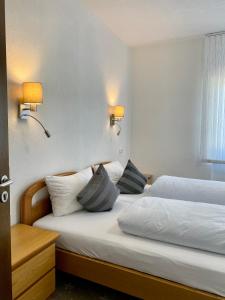 - 2 lits dans une chambre d'hôtel avec 2 lampes dans l'établissement Hotel Alessandro, à Neuried