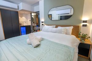 Schlafzimmer mit einem großen weißen Bett und einem Spiegel in der Unterkunft Davidka Guesthouse in Jerusalem