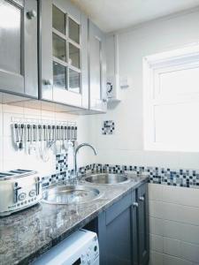 a white kitchen with two sinks and a window at Dune Roamin': Sea Palling's Treasure - NOW with TV in Norwich +39 photos