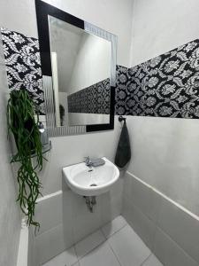 La salle de bains est pourvue d'un lavabo et d'un miroir. dans l'établissement TymCast's Place - 2 Story house, à Kabankalan