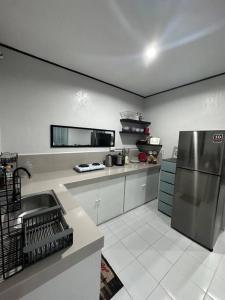 a large kitchen with a stainless steel refrigerator at TymCast's Place - 2 Story house in Kabankalan