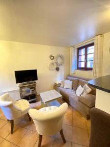 a living room with a couch and a tv at Le Riquewihrien in Riquewihr