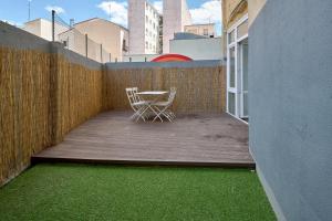 Casita Mela - Apt. p/8 pax con terraza en Logroño في لوغرونيو: طاولة وكراسي على شرفة مع عشب أخضر