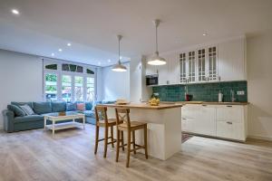 a kitchen and living room with a blue couch at Casita Mela - Apt. p/8 pax con terraza en Logroño in Logroño