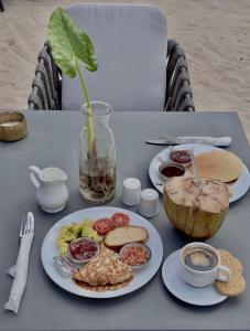 a table with a plate of food and a coconut on it at V Hotel in Paje in Paje