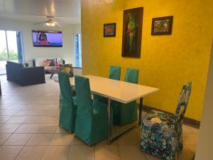 a dining room with a table and green chairs at Exclusivo departamento frente al mar en Same, Casa Blanca in Same