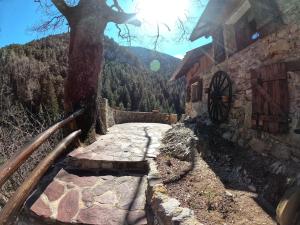 un chemin en pierre à côté d'un bâtiment avec un arbre dans l'établissement Maison Maralpine, à Roubion