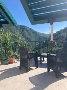 BorzonascaにあるCamere e accoglienza LA CASA DELLA NONNAの山々を背景にテーブルと椅子付きのパティオ