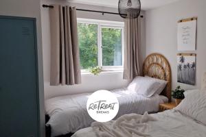 sypialnia z 2 łóżkami i oknem w obiekcie ReTreat Breaks - 3 Bedroom Penthouse - Holbeck Leeds w mieście Leeds