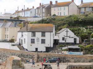 eine Gruppe von Menschen, die vor einem weißen Gebäude stehen in der Unterkunft Courtyard in Porthleven