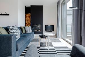 een woonkamer met een blauwe bank en een tv bij Dune Villa 7 in Zandvoort