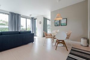 een woonkamer met een blauwe bank en een tafel bij Dune Villa 7 in Zandvoort
