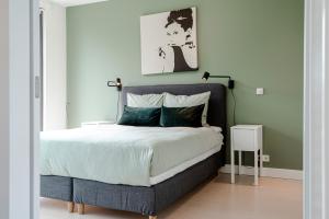 een slaapkamer met een groot bed met groene muren bij Dune Villa 7 in Zandvoort