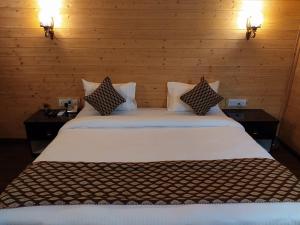 una camera da letto con un grande letto bianco con due tavoli di Ganges Grand a Varanasi