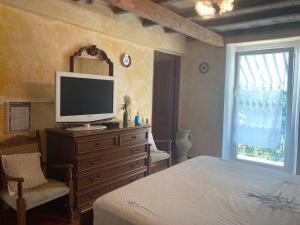 a bedroom with a bed and a television on a dresser at Camere e accoglienza LA CASA DELLA NONNA in Borzonasca