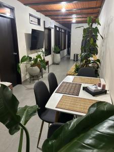 a meeting room with tables and chairs and potted plants at 301 HomeVibes in Cali