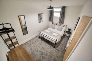 a bedroom with a bed and a mirror on the wall at High Spec Spacious 2BD Apt, Parking, Nr Newcastle in Gateshead