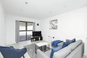 Sala de estar blanca con 2 sofás y TV en Modern Home in Derby City Centre - Free Gated Parking en Derby