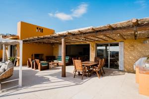 a patio with a wooden pergola and a table and chairs at Ocean view, pool & gated community in Cabo San Lucas
