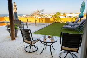 a patio with chairs and a table and umbrella at Ocean view, pool & gated community in Cabo San Lucas