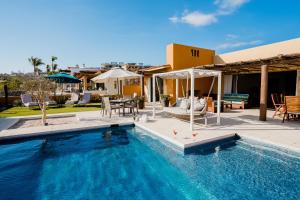 a swimming pool in front of a house at Ocean view, pool & gated community in Cabo San Lucas