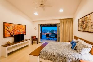 a bedroom with a bed and a flat screen tv at Ocean view, pool & gated community in Cabo San Lucas