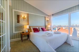 um quarto com uma grande cama branca e uma grande janela em Olissippo Castelo em Lisboa