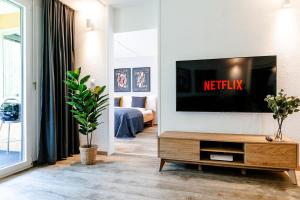 uma sala de estar com uma televisão de ecrã plano na parede em Spirit Apartments - Suite #1 - Balkon - Bergsicht em Engelberg