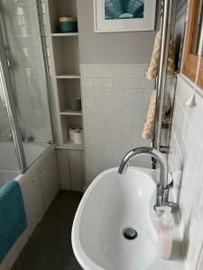 a white bathroom with a sink and a shower at Pretty Cottage in Central Lewes in Lewes