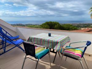 Palm Maresme - Suite with bathroom and living-room and terrasse with ocean views in a private villa في Vilassar de Dalt: طاولة وكراسي على شرفة مطلة