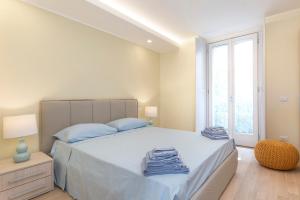 a bedroom with a bed with blue sheets and a window at Mono Via Bellinzona in Como