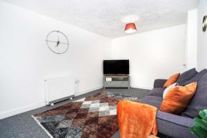 a living room with a couch and a tv at Springland Close in Ipswich