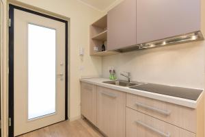 una cocina con fregadero y una ventana junto a una puerta en Mono Via Bellinzona en Como