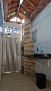 a kitchen with a brick wall and a sink at Pipa Céu Azul in Pipa +35 photos