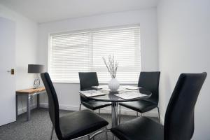 a dining room with a table and black chairs at Springland Close in Ipswich