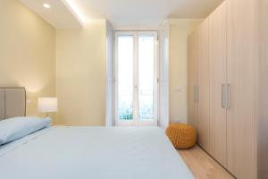 a bedroom with a large white bed and a window at Mono Via Bellinzona in Como