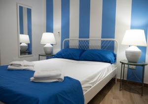 1 dormitorio azul y blanco con 1 cama y 2 lámparas en Carpeviam - Guesthouse, en Benevento