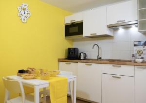 una cocina con armarios blancos y una mesa con sillas. en Carpeviam - Guesthouse, en Benevento
