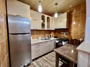 eine Küche mit einem Kühlschrank aus Edelstahl und einem Tisch in der Unterkunft Apartment in the city in Kutaissi