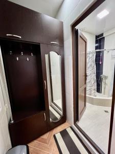 ein Bad mit einem großen Spiegel und einer ebenerdigen Dusche in der Unterkunft Apartment in the city in Kutaissi