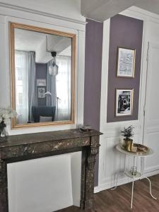 uma sala de estar com lareira e espelho em Le 1675_I - Confort et charme de l'ancien em Rouen