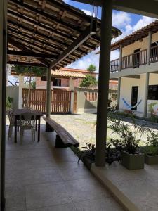 eine Terrasse mit einer Holzbank und einem Tisch in der Unterkunft Pousada Villas do Arraial in Arraial d'Ajuda